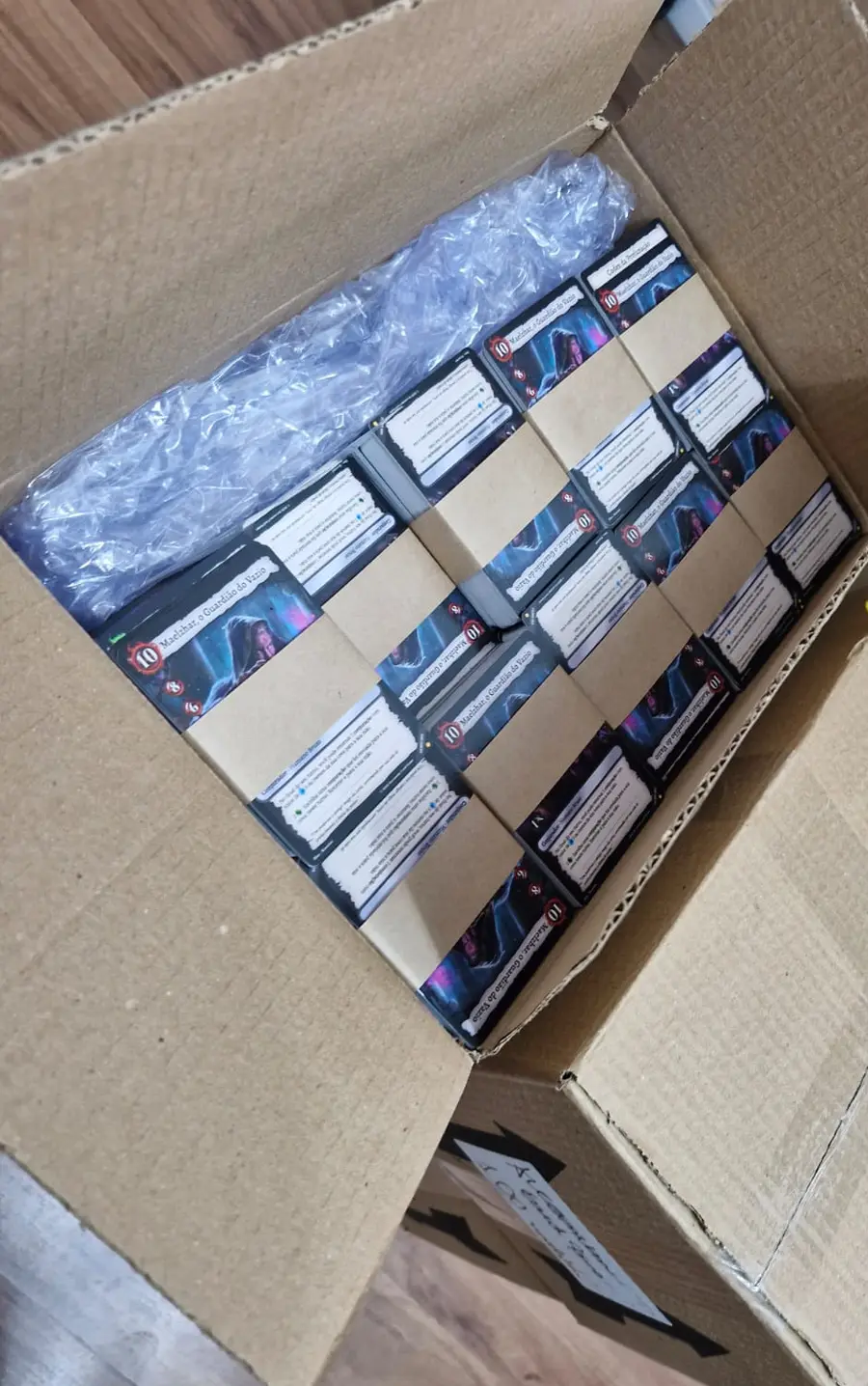 Stacks of Arcanum cards laid side by side inside the box during the check