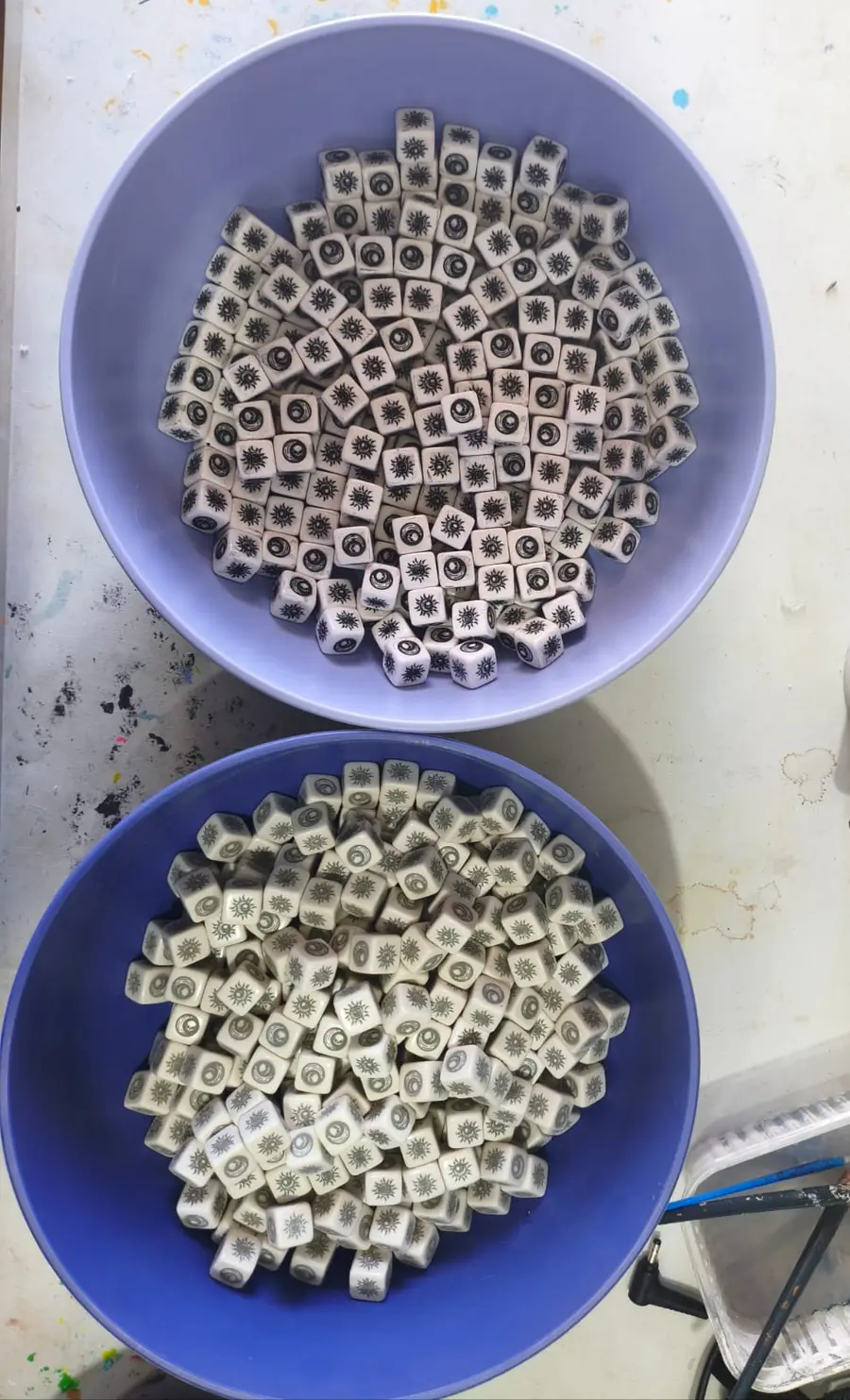 Duas tigelas cheias de dados brancos do Arcanum com símbolos gravados nas faces