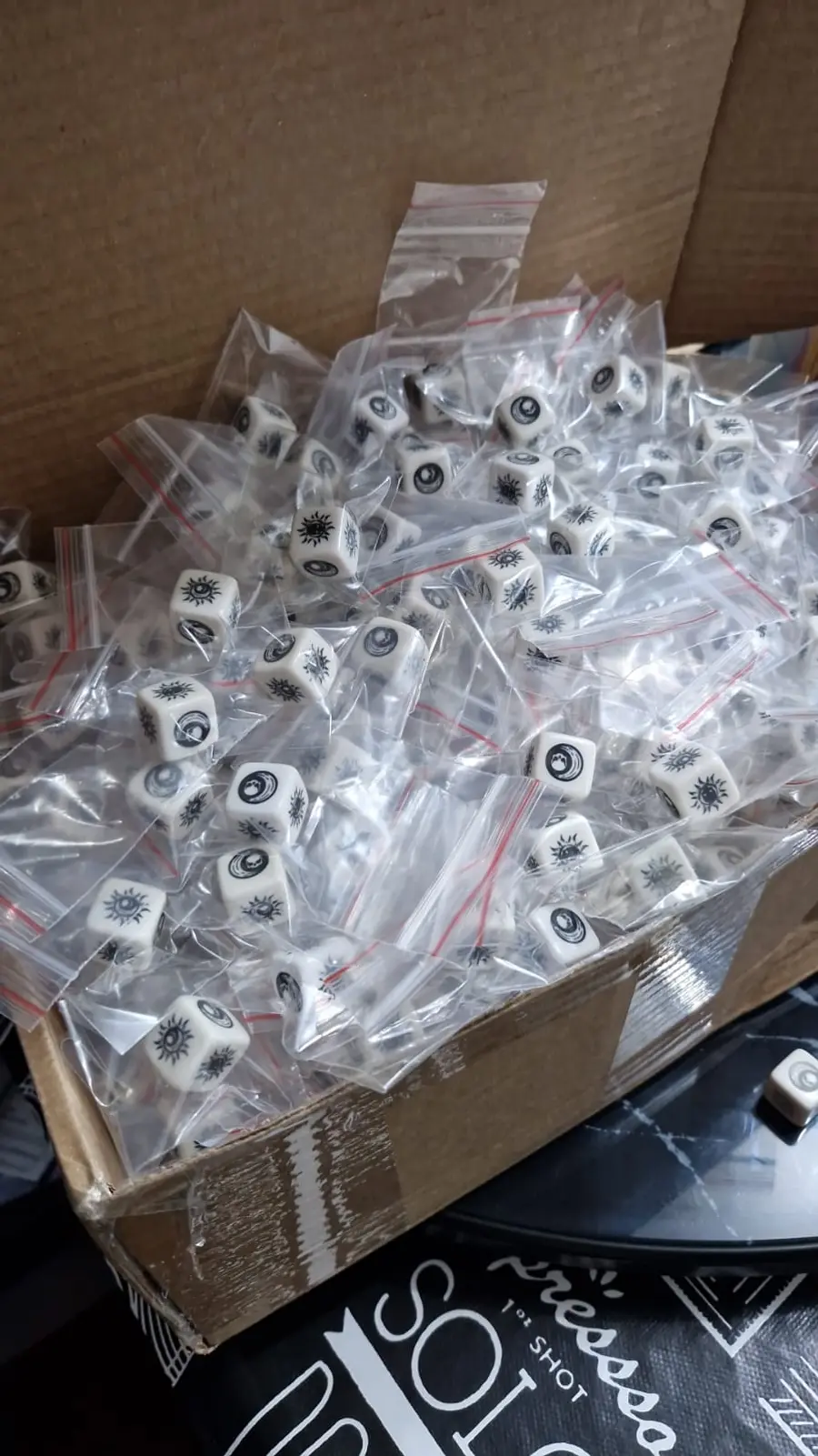 Box full of Arcanum dice, each one individually bagged